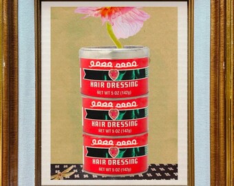 May include: A framed image of a pink flower growing out of three stacked red cans. The cans are labeled "00000000 Hair Dressing Net Wt 5 oz (142g)".