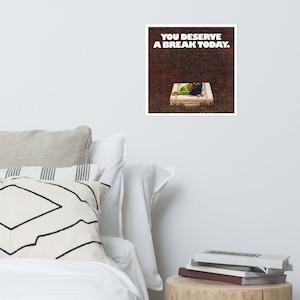 May include: A white square with black text that reads "YOU DESERVE A BREAK TODAY."  A person is lying on a white mattress in a grassy area.