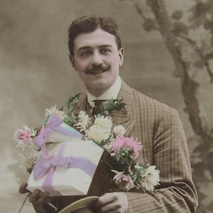 Original glossy postcard of a man with some flowers, a present and his hat, old postcard, vintage postcard men