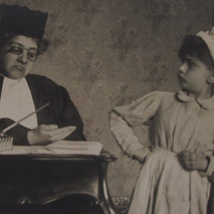 Antique postcard of a girl and boy who play judge and accused, old postcard, vintage postcard