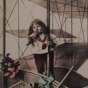 Carte postale vintage brillante d'un petit garçon dans un avion avec quelques fleurs, carte postale ancienne, carte postale ancienne enfants