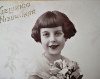 shiny postcard of a pretty little girl with flowers, vintage postcard