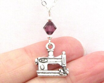 May include: A silver sewing machine charm necklace with a purple crystal bead.