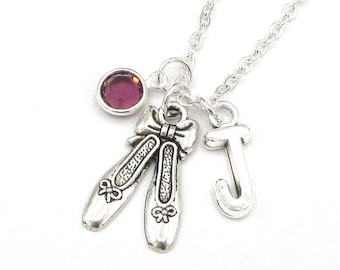 May include: Silver necklace with a ballet shoe charm, a letter J charm, and a purple gemstone.