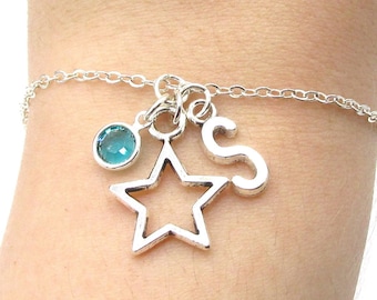 May include: A silver chain bracelet with a star charm, a letter 'S' charm, and a light blue gemstone.