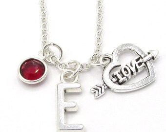 May include: Silver necklace with a red gemstone, a letter E charm, and a heart charm with the word "love" and an arrow through it.