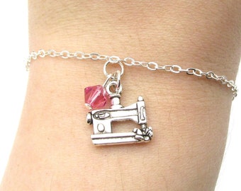 May include: A silver chain bracelet with a silver sewing machine charm and a pink crystal bead.