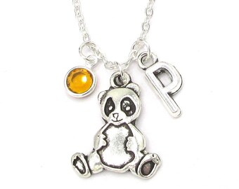 May include: Silver necklace with a panda charm, a letter 'P' charm, and a small amber-colored gemstone.