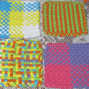 May include: Four colorful woven pot holders, each with a different pattern. The pot holders are made with a variety of colors, including blue, yellow, green, orange, purple, and pink.