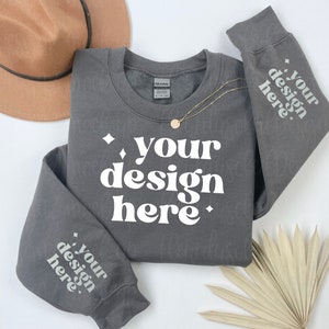 May include: A charcoal grey sweatshirt with the text "your design here" printed in white on the front and both sleeves.