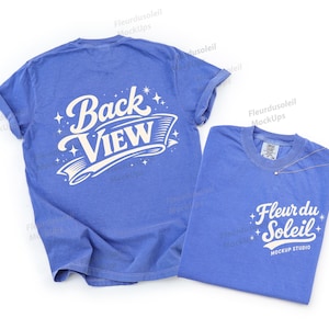 May include: Two blue t-shirts. One displays "Back View" in white script, the other features "Fleur du Soleil Mockup Studio" in white script. The shirts are laid flat, showcasing the design and style.