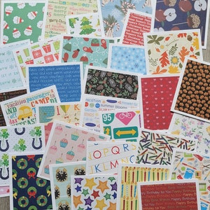 May include: A collection of colorful patterned paper squares with various designs, including holiday themes, alphabet letters, and nature scenes. The papers are perfect for scrapbooking, card making, and other craft projects.