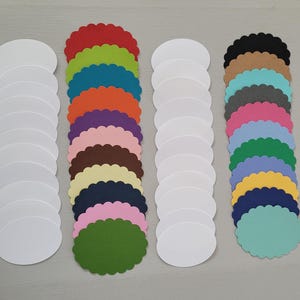 May include: A set of 24 scalloped circles in various colors, including red, green, blue, orange, purple, brown, yellow, pink, and teal. The circles are arranged in two rows, with the top row featuring plain white circles.