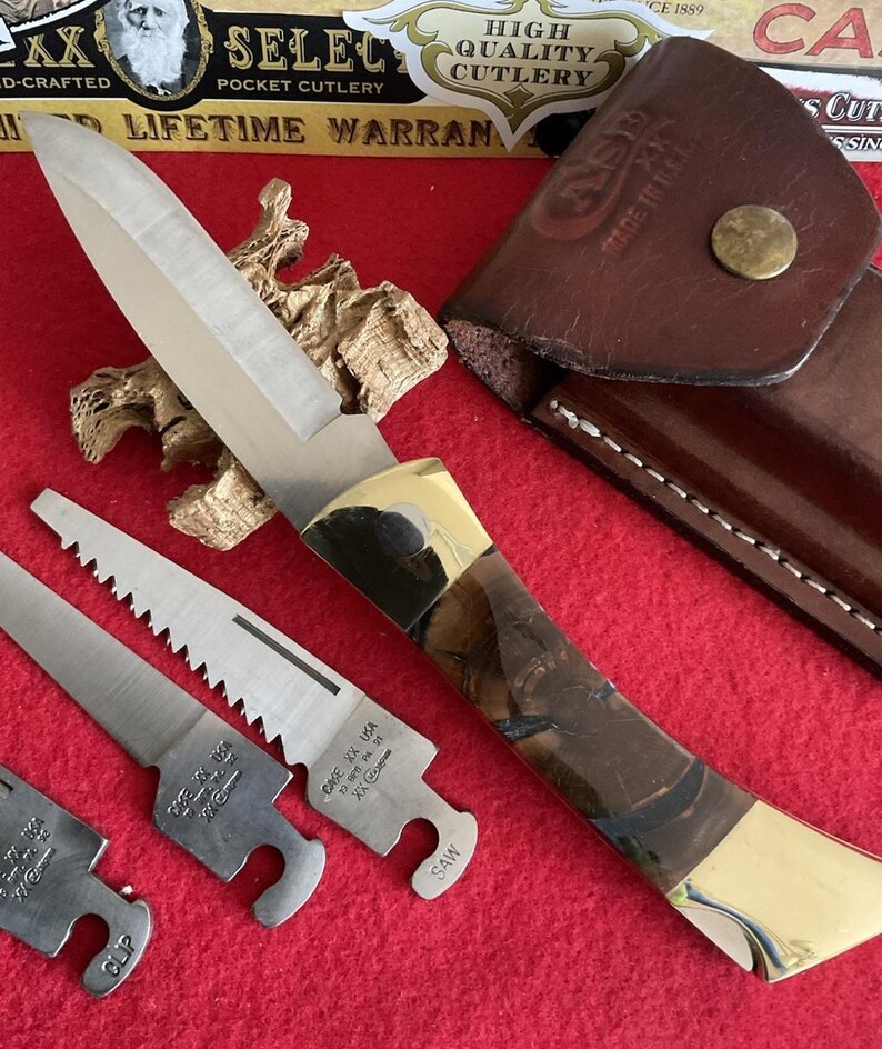 Puede incluir: Una navaja de bolsillo de varias hojas con una hoja de acero pulido y un mango marr&oacute;n y dorado. Incluye una funda de cuero y hojas de sierra y clip adicionales. El cuchillo est&aacute; marcado "CASE XX USA".