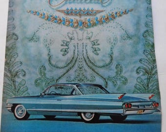 May include: A vintage advertisement for Cadillac featuring a blue Cadillac car against a blue and white patterned background. The text reads "A new Cadillac car is one of the few material possessions for which there is no completely acceptable substitute."
