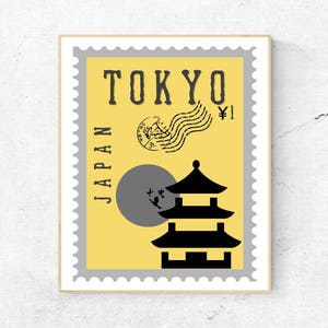 May include: A yellow and gray vintage-style postage stamp with the text "TOKYO" and "JAPAN" printed vertically. The stamp features a black silhouette of a pagoda with a gray circle and birds flying around it. The stamp also has the text "¥1" printed in the top right corner.