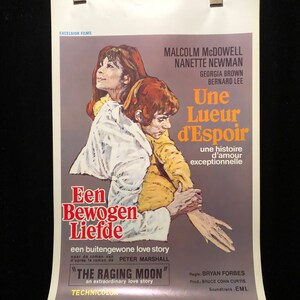 Op de afbeelding: Een vintage filmposter voor de film "The Raging Moon" met Malcolm McDowell en Nanette Newman. De poster toont een close-up van de twee acteurs die elkaar omarmen, met de titel van de film in grote, vetgedrukte letters. De poster is in een gedempte kleurenpalet van bruin, geel en oranje.