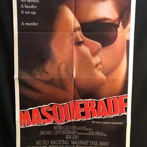 May include: A film poster for the movie "Masquerade" starring Rob Lowe, Meg Tilly, Kim Cattrall, and Doug Savant. The poster features a close-up of a man and woman embracing, with the man wearing sunglasses. The text "It's not a game anymore." is featured at the bottom of the poster.