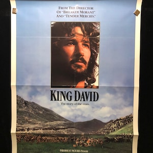 May include: A movie poster for the film "King David" starring Richard Gere. The poster features a close-up of Gere's face with a beard and long hair. The text on the poster reads "From the director of "Breaker Morant" and "Tender Mercies." King David. The story of the man."