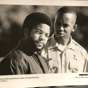 May include: Black and white photo of two men, Ice Cube and Michael Boatman, in a scene from the movie "The Glass Shield".