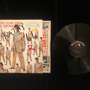 May include: A vinyl record album cover featuring Elvis Presley in a gold suit. The cover has the text "50,000,000 Elvis Fans Can't Be Wrong" and "Elvis Gold Records - Volume 1".