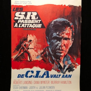 Puede incluir: Un cartel de película vintage para la película "Los S.I.R. atacan" protagonizada por Robert Lansing, Dana Wynter y Murray Hamilton. El cartel presenta un esquema de color rojo, blanco y azul con un diseño gráfico audaz. El texto en el cartel dice "Les S.I.R. Passent A L'Attaque" y "De C.I.A. Valt Aan".