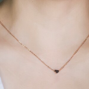 K&ouml;nnte beinhalten: Eine zarte Halskette aus Ros&eacute;gold mit einem kleinen Herzanh&auml;nger. Die Kette ist fein und das Herz hat einen dunkleren Ros&eacute;goldton. Die Halskette wird vor einem neutralen Hintergrund pr&auml;sentiert.