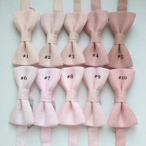 May include: A collection of ten bow ties in various shades of pink, ranging from light blush to deeper rose. Each bow tie is numbered from #1 to #10, showcasing a range of color options for formal wear or special occasions.
