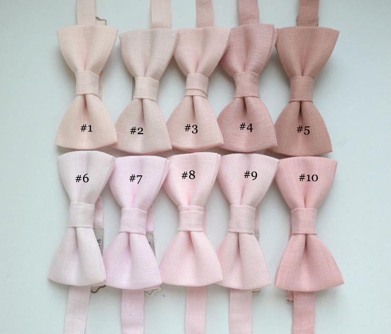 May include: A collection of ten bow ties in various shades of pink, ranging from light blush to deeper rose. Each bow tie is numbered from #1 to #10, showcasing a range of color options for formal wear or special occasions.