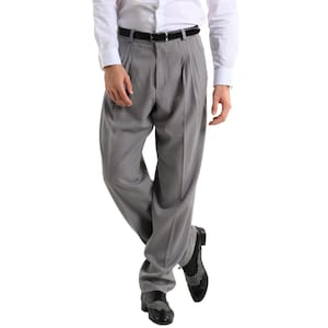 Peut inclure: Pantalon gris plissé avec une ceinture noire et des chaussures noires.