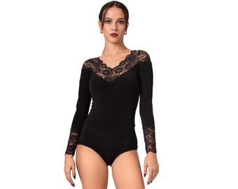 May include: Black bodysuit with long sleeves and a V-neckline. The neckline and sleeve cuffs are adorned with delicate black lace. The garment is form-fitting and appears to be made of a soft, stretchy material.