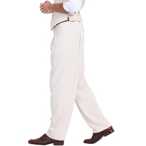 May include: A white pair of dress pants with a brown leather belt. The pants are pleated and have a wide leg.