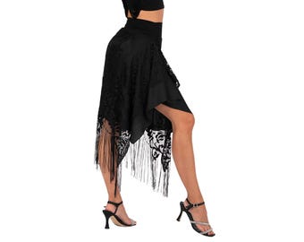 May include: Black asymmetrical dance skirt with a high waist and fringe detail. The skirt features a floral lace pattern and is paired with black high-heeled sandals. The skirt is designed for dance performances.