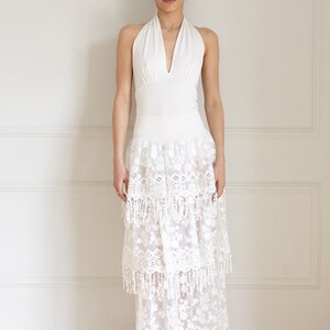 May include: A white halter top with a lace skirt. The skirt has multiple layers and a fringe trim.