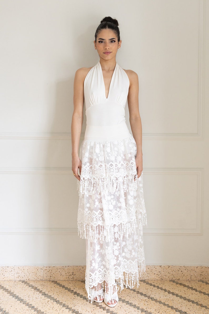 May include: A white halter top with a lace skirt. The skirt has multiple layers and a fringe trim.