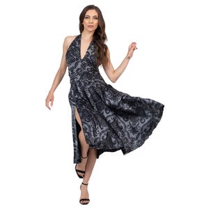 Könnte beinhalten: Ein ärmelloses Neckholder-Kleid mit einem dunkelgrauen und schwarzen Samtmuster im Damast-Stil. Das Kleidungsstück hat einen tiefen V-Ausschnitt, ein eng anliegendes Oberteil und einen fließenden Rock mit einem hohen Seitenschlitz am Bein.