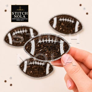 May include: A brown football-shaped patch featuring dark brown sequins, white embroidered laces, and a silver glitter border. The patch is held in place, while three identical football patches are arranged in the background with a logo.