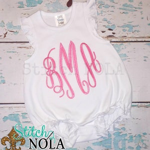 May include: White baby onesie with pink ruffled sleeves and a pink monogrammed letter "B" on the front. The onesie is made by "CBB Blanks" and is size 3-6M.
