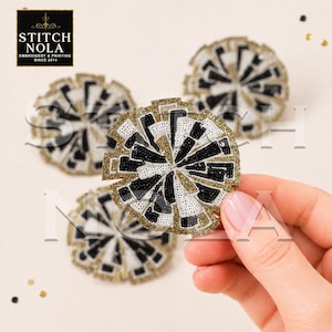 May include: Three circular cheerleading pom-pom patches featuring black, white, and gold sequins arranged in a radial pattern. The patches have a textured, beaded appearance with a gold glitter border. The text STITCH NOLA EMBROIDERY & PRINTING SINCE 2014 is visible in the top left corner.