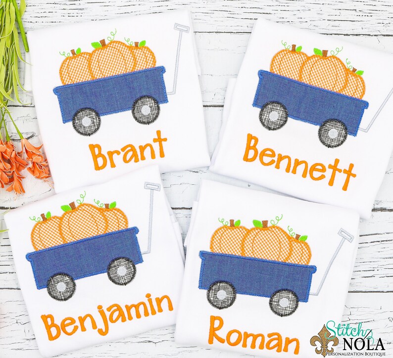 Puede incluir: Cuatro camisetas blancas con un carro azul y calabazas naranjas bordadas. Cada camiseta tiene un nombre diferente bordado: Brant, Bennett, Benjamin y Roman.