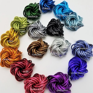 May include: A collection of 14 colorful metal fidget toys in various colors, including emerald green, cobalt blue, turquoise, winter blue, onyx black, quicksilver, gold, lavender, silverstar, caramel, orange, ruby, sable rose, and amethyst.