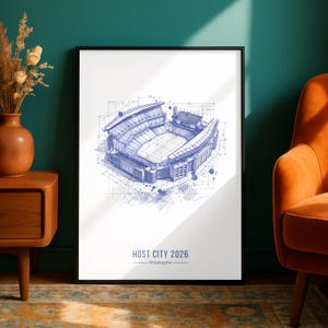 May include: A framed vertical art print featuring a blue ink architectural sketch of a stadium. The drawing includes technical lines and measurements. Below the illustration, the text reads HOST CITY 2026 Philadelphia in blue capital letters.