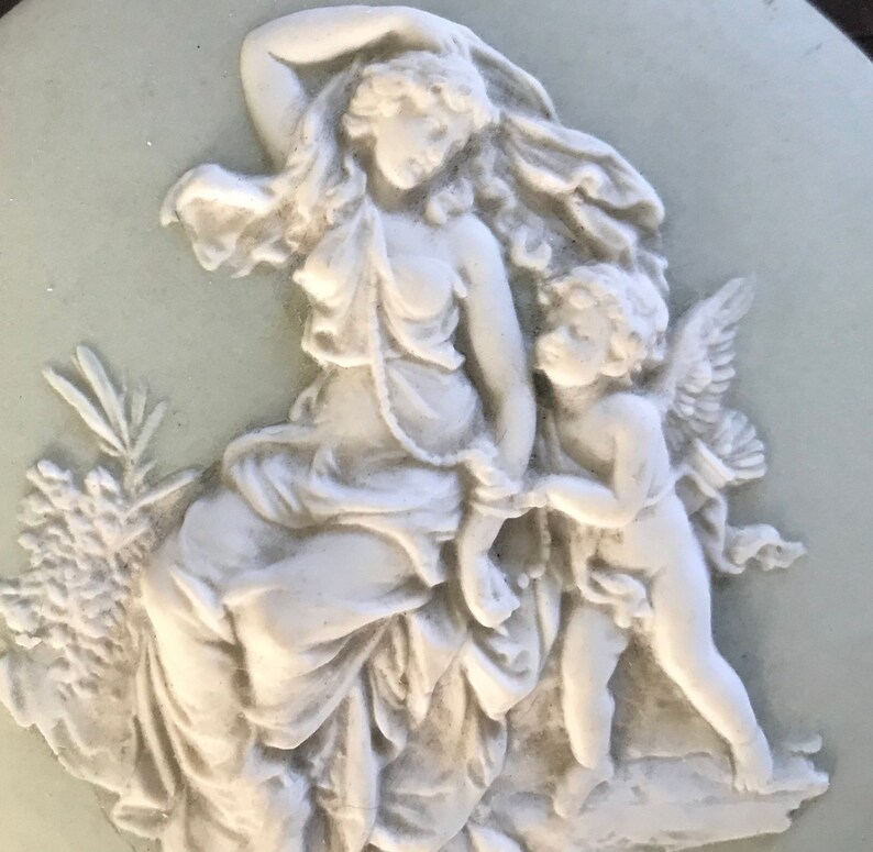 probably Wedgwood Small round green china plate with antique decor of a woman with angel