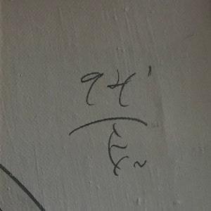 May include: Handwritten signature with the text "94'" above a stylized symbol resembling a stylized "E" with a squiggly line.