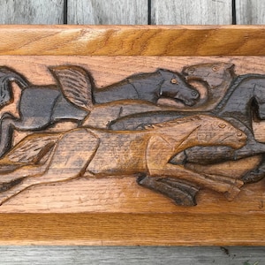Carved wooden panel, galloping horses
