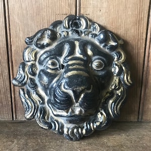 Metal lion head painted black and gold