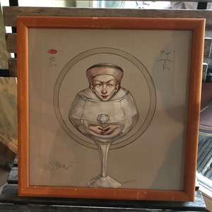 May include: A framed painting depicting a person's head inside a wine glass. The person is wearing a white hat and has a fair complexion. The painting is set against a grey background and features a red circle in the top left corner. The painting is signed in the bottom left corner.