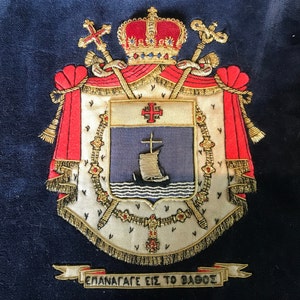 Pode incluir: Um brasão bordado a ouro com uma coroa vermelha e branca, um escudo vermelho e branco com uma cruz e um navio, e uma faixa dourada com o texto "ΕΠΑΝΑΦΑΓΕ ΕΙΣ ΤΟ ΒΑΘΟΣ".