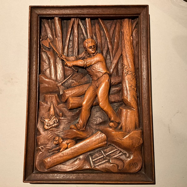 Bas relief en bois sculpté   Jeune bûcheron dans la forêt avec son chien, signé AD