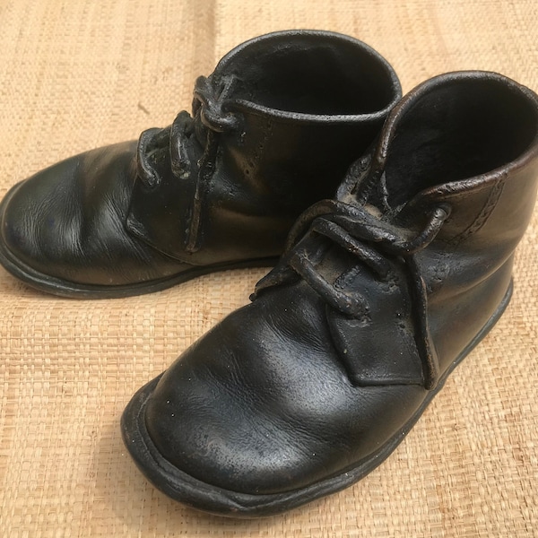 Paire de premières chaussures d’enfant. Chaussures couvertes de cuivre.chaussures décoratives